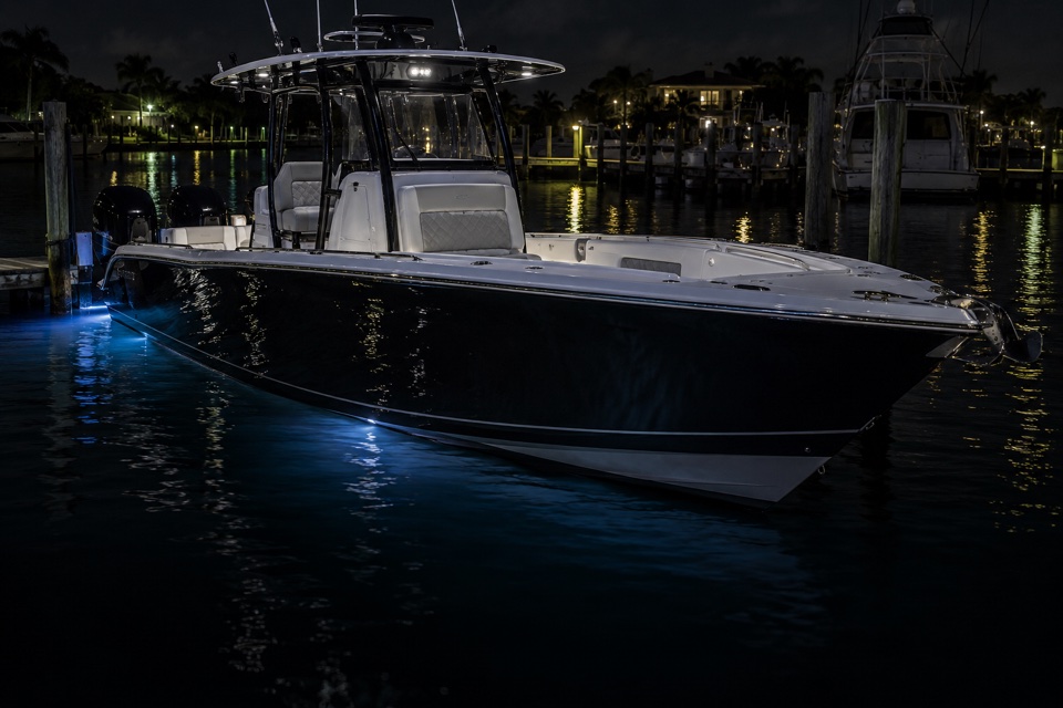 Boat with illuminated hull at a marina at night